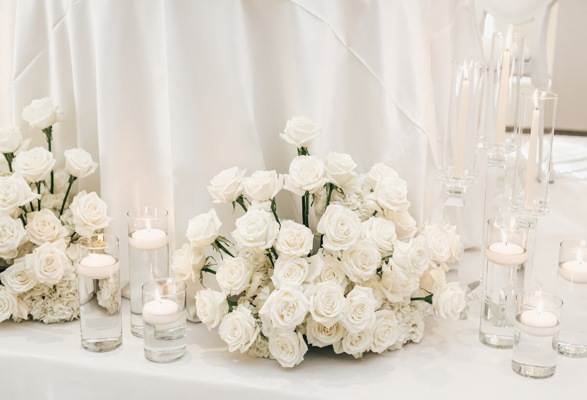 Elegant white roses and candles for any black tie wedding reception