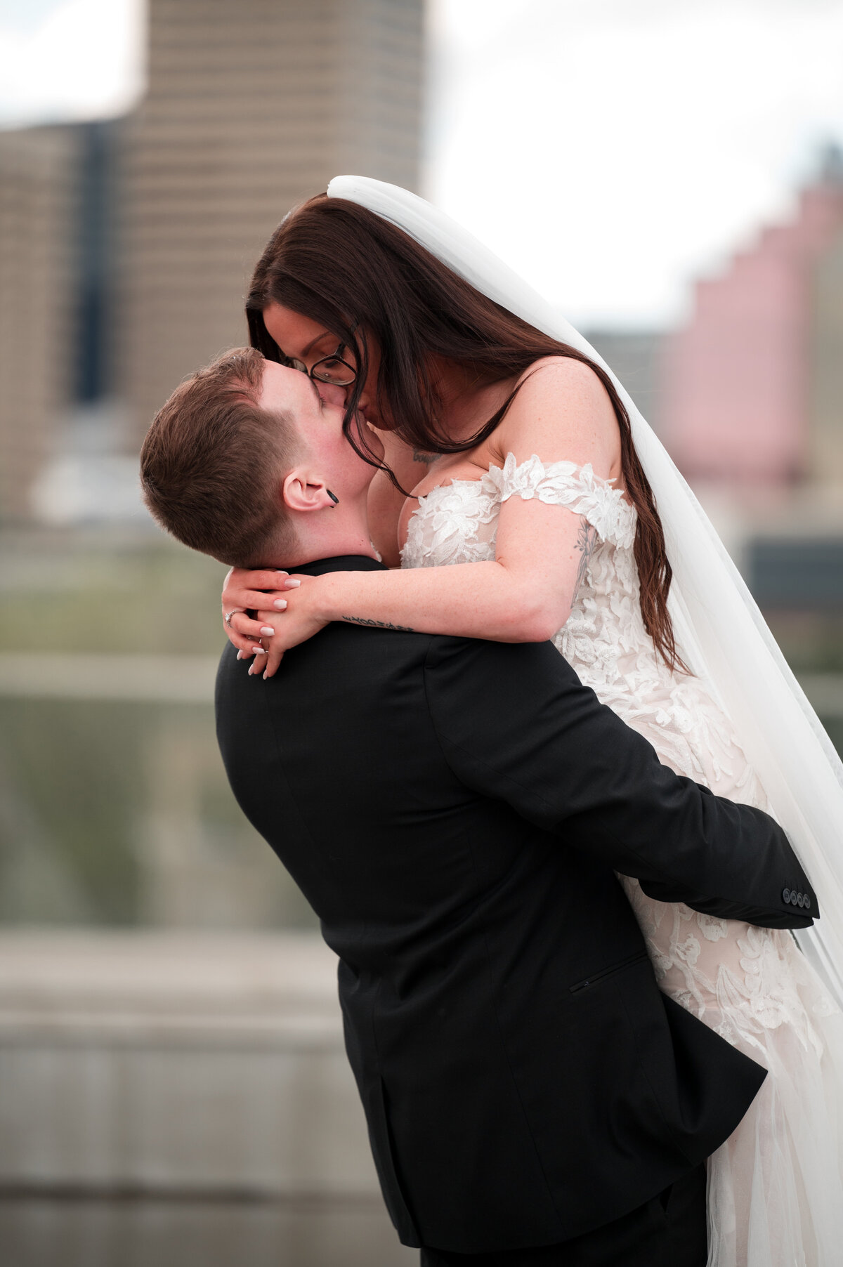 groom holding bride and kissing her