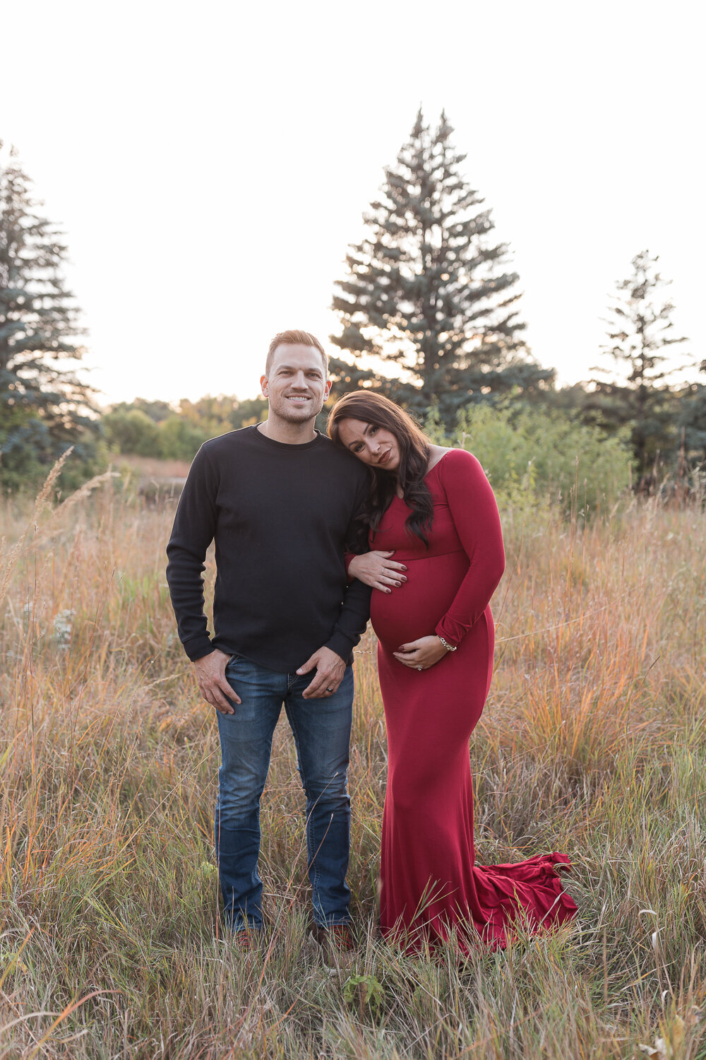pregnant mom holding dads arm smiliing