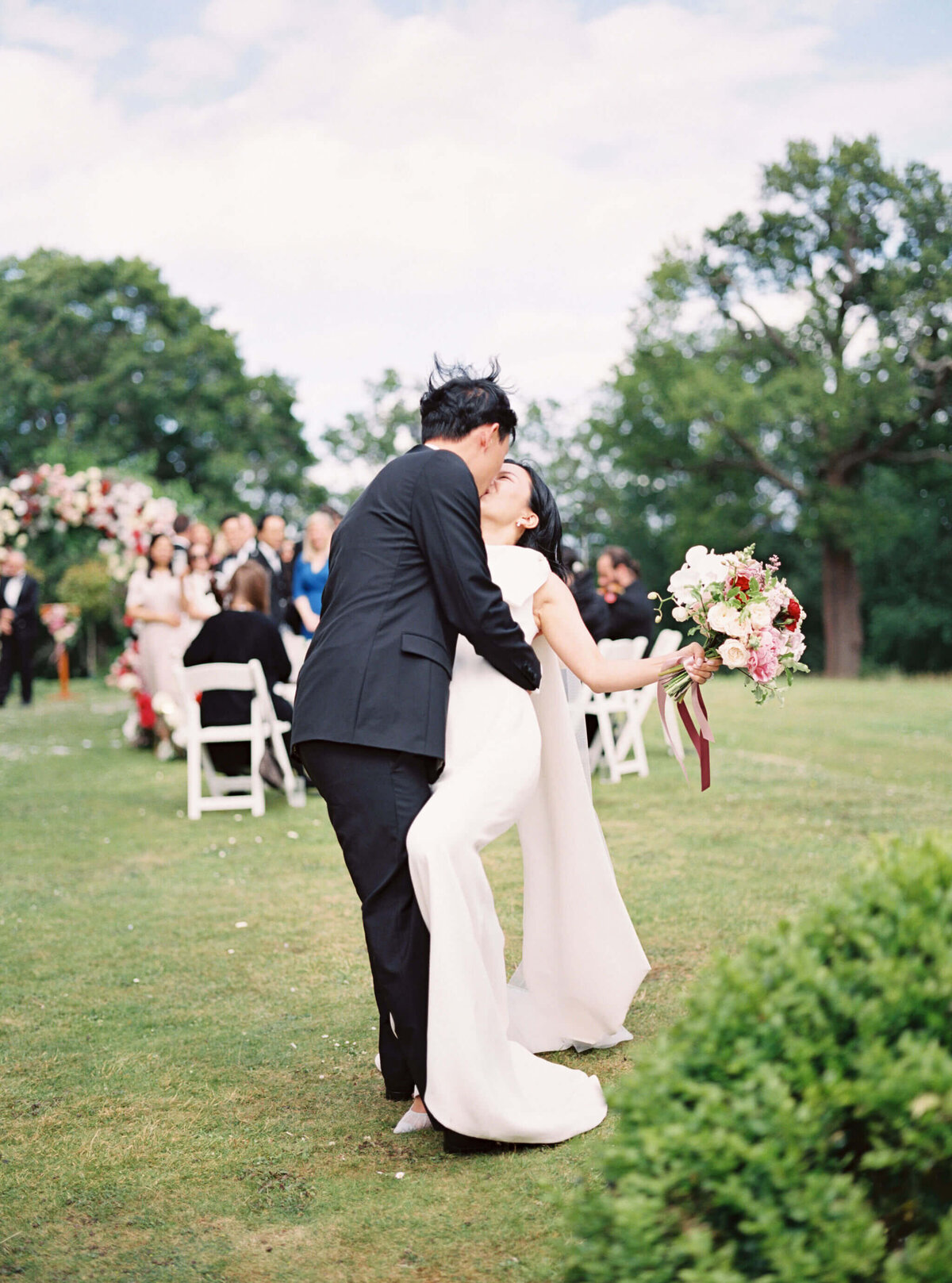 groom dipping the bride and kissing at botleys mansion outdoor wedding