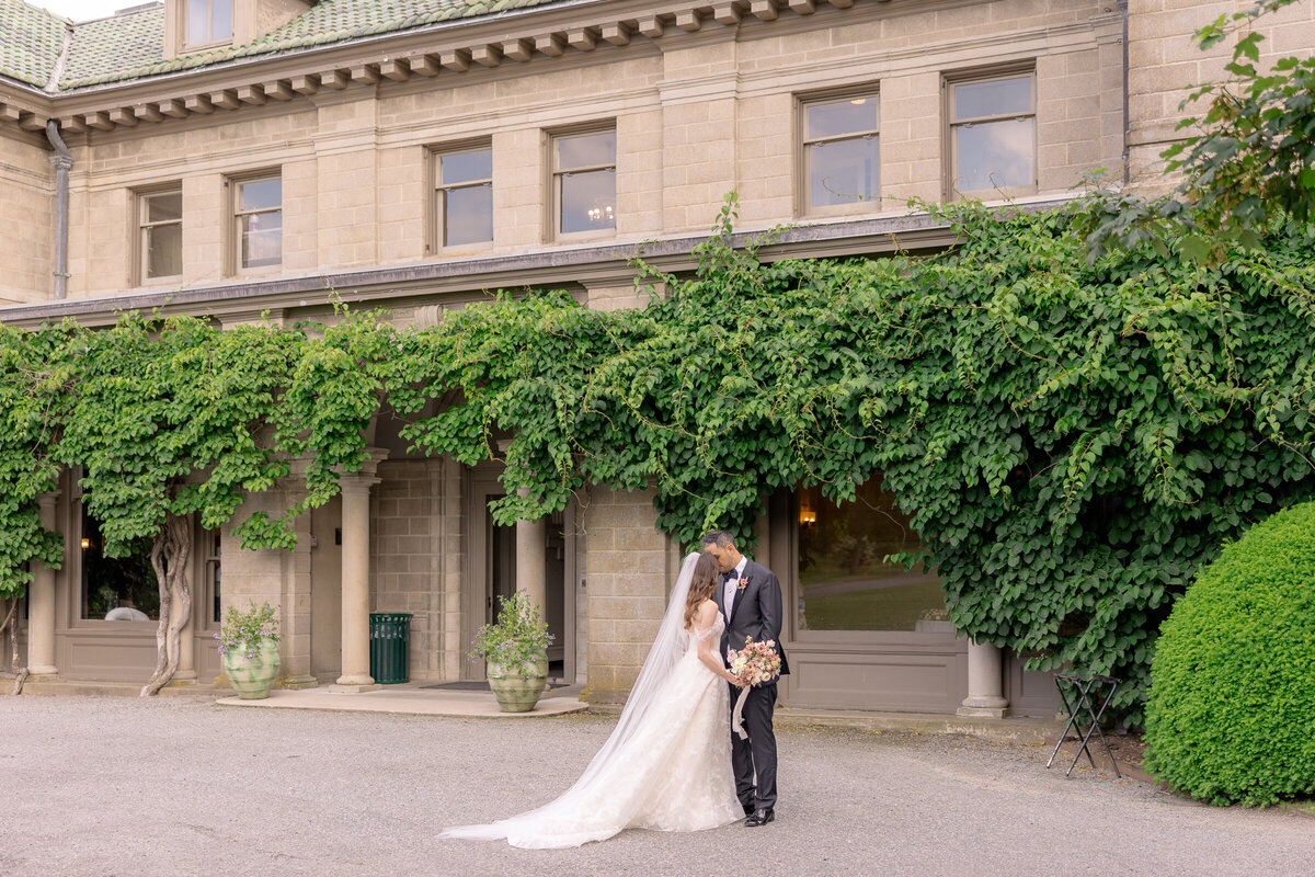 ethereal and elegant bride and groom posing in front of mansion in Connecticut