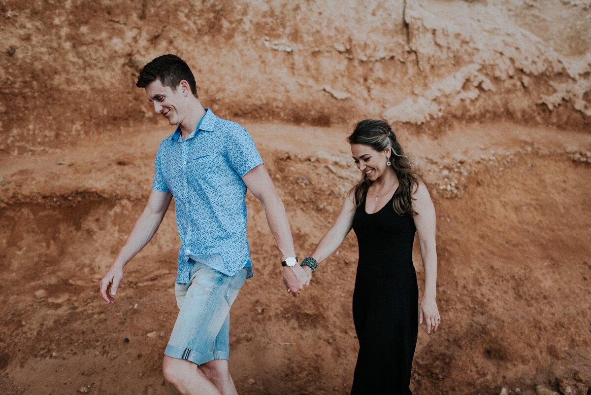 Devon Wedding Photographer Liberty Pearl Photography and her husband walking along the face of a liff