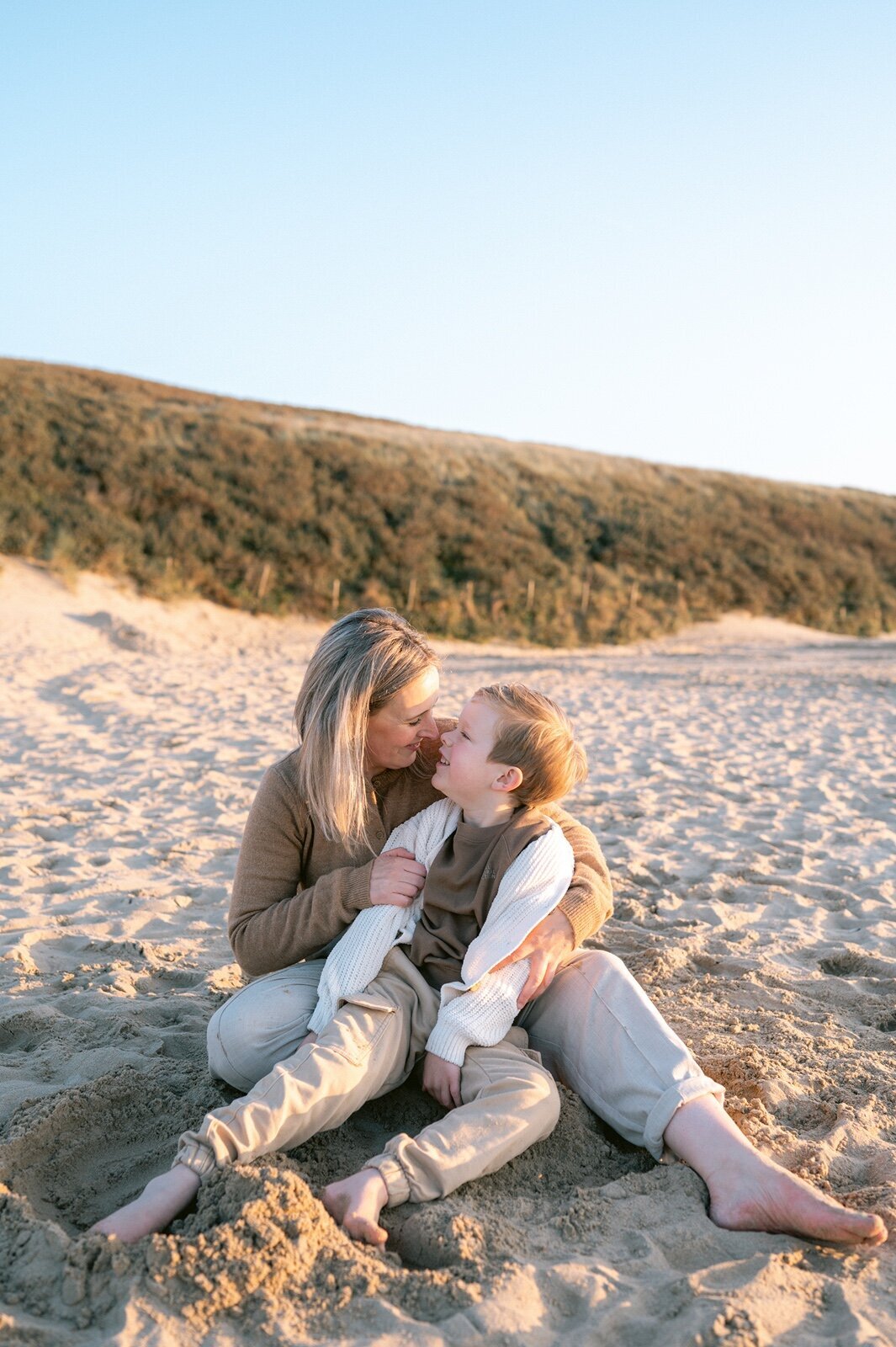 Moeder en zoon neuzen met elkaar op het strand
