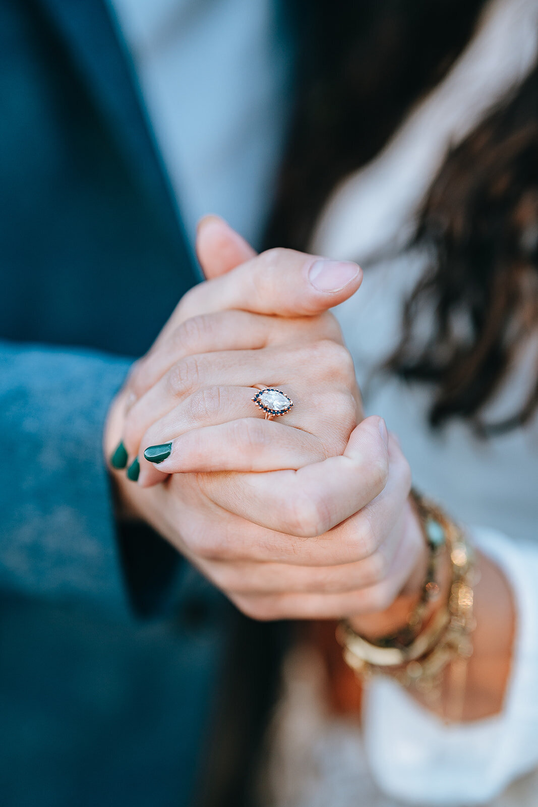 engaged couple holding hands showing engagement ring