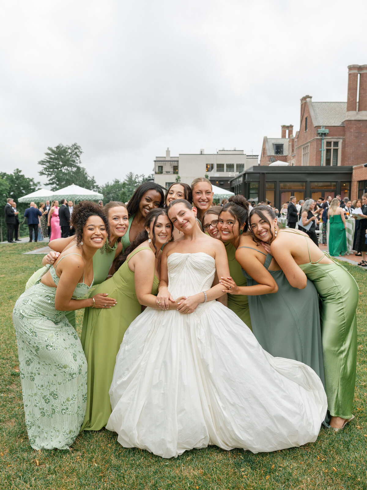 Kara surrounded by her bridesmaids in sage green gowns on the lawn at Pendry Natirar