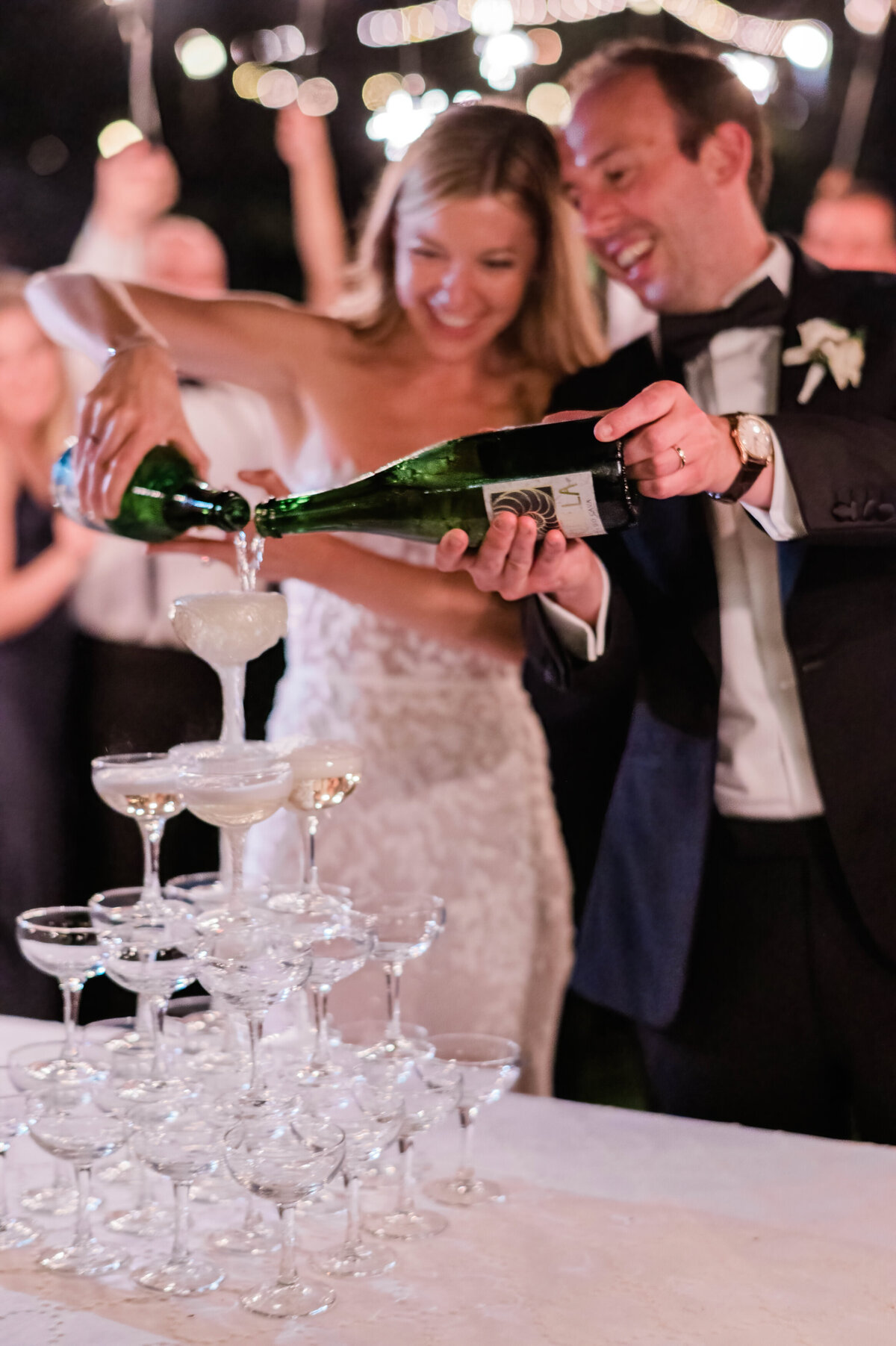 Bride and groom pour champagne together