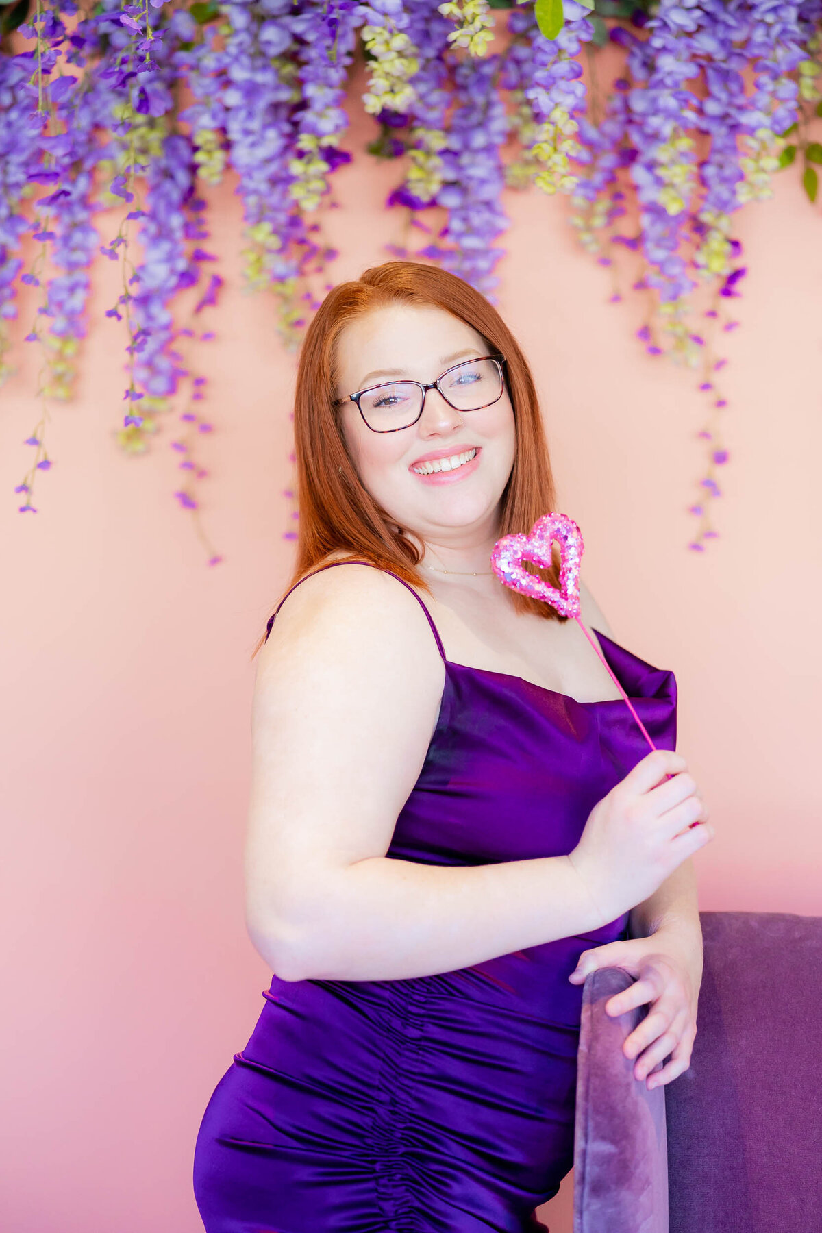 beautiful redhead in purple dress with a heart in a valentine's sessioni