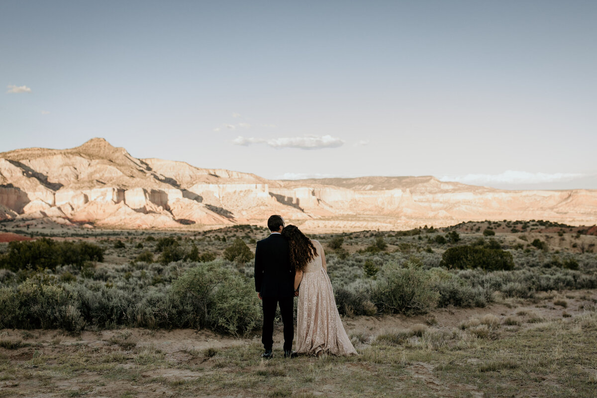 bride and groom looking at a New Mexico mountain