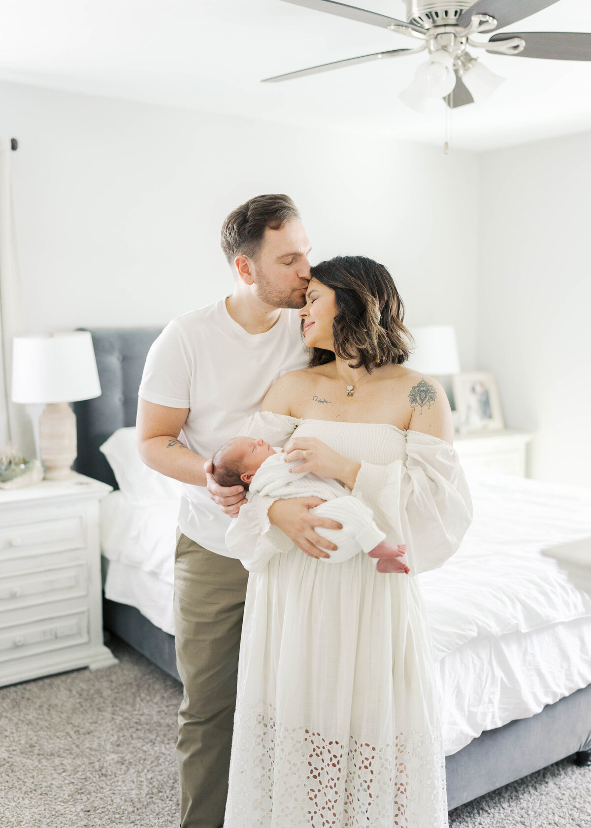 mom and dad holding baby in arms while baby is sleeping in virginia beach newborn photography session