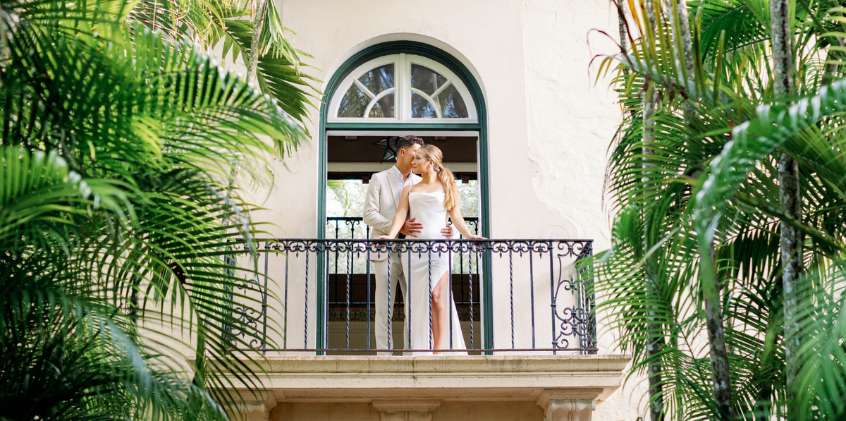 Bride and groom embracing on a balcony at Villa Woodbine in Miami, by Claudia Amalia Photography.