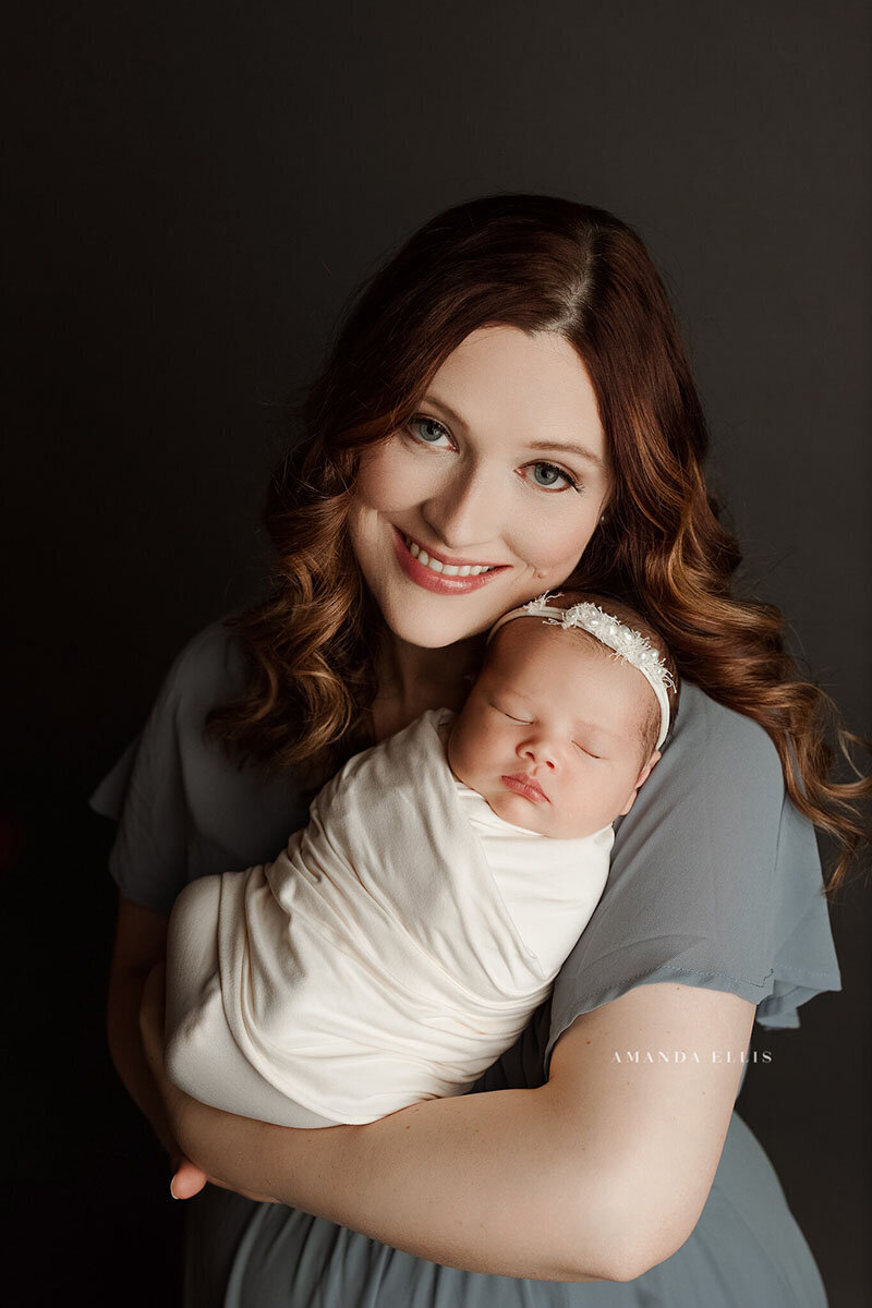 Stunning portrait of mother looking into the camera with newborn