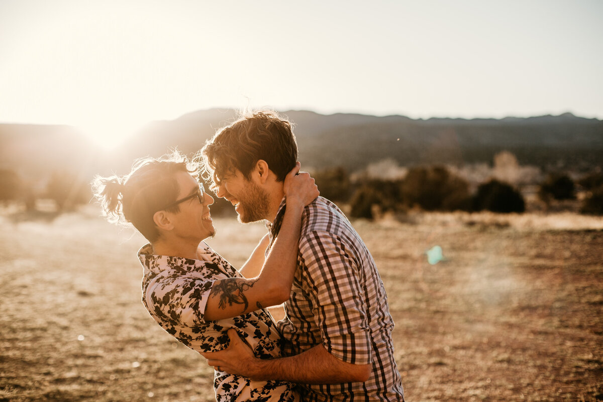 same sex couple about to kiss with sun flare
