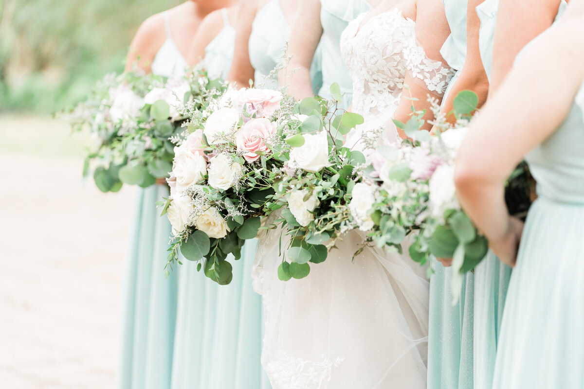 Bridesmaids in turquoise dresses and white bouquets