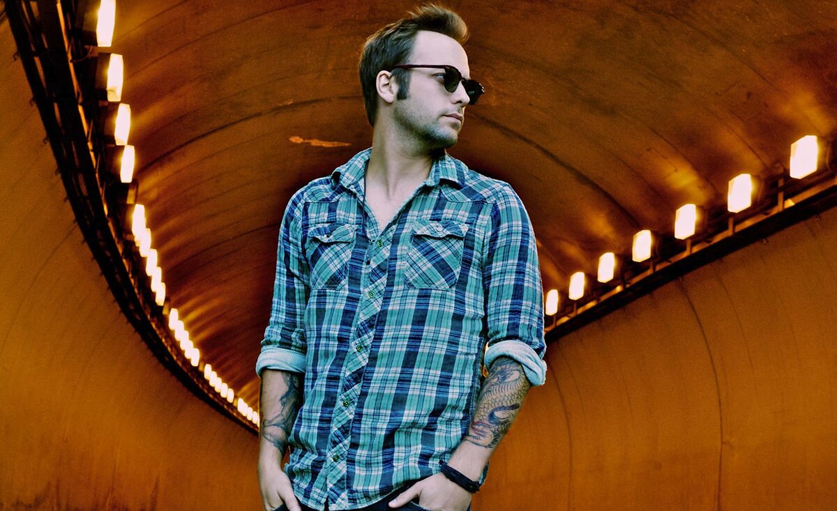 Country musician portrait Dallas Smith wearing sunglasses plaid shirt tunnel lights background