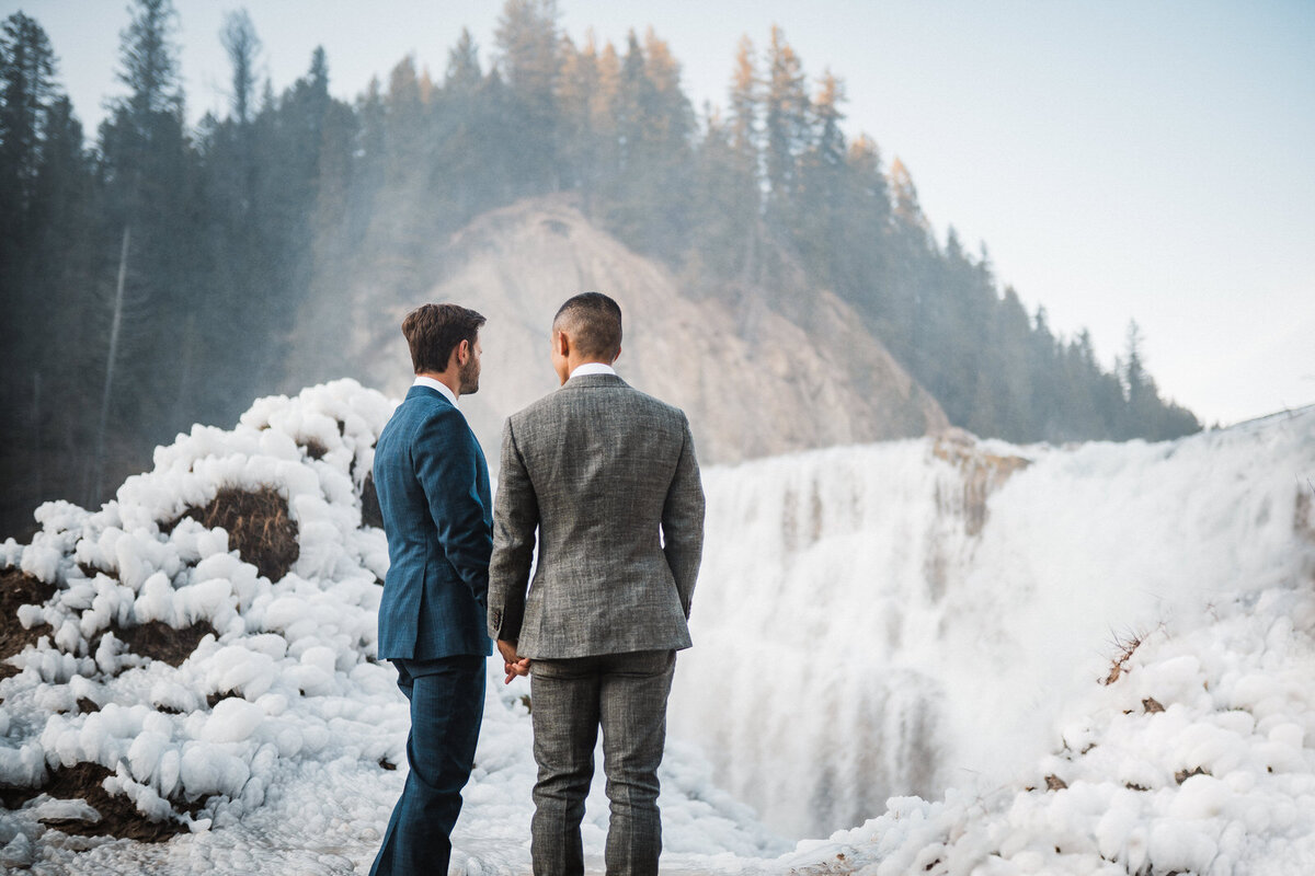 bride and groom walking across mountain scape