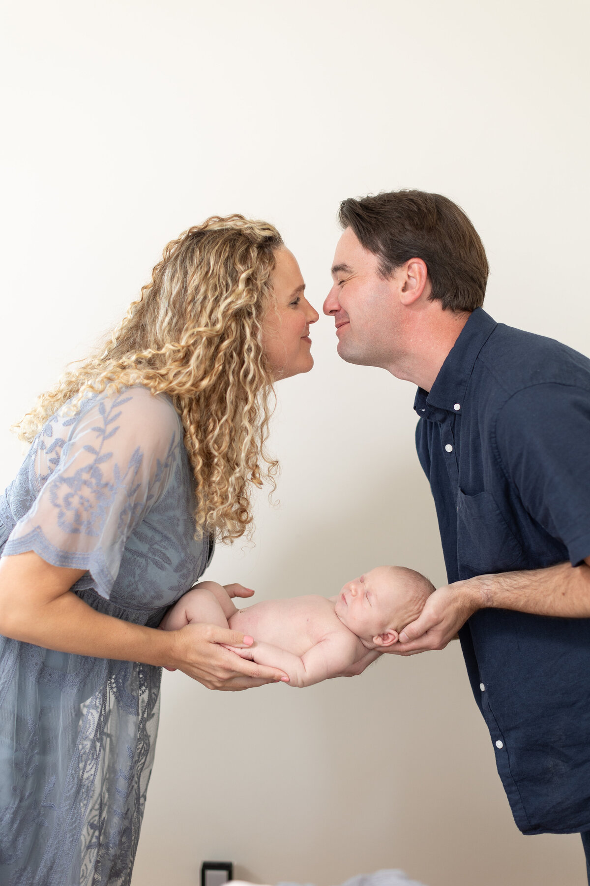 Couple kissing holding a baby