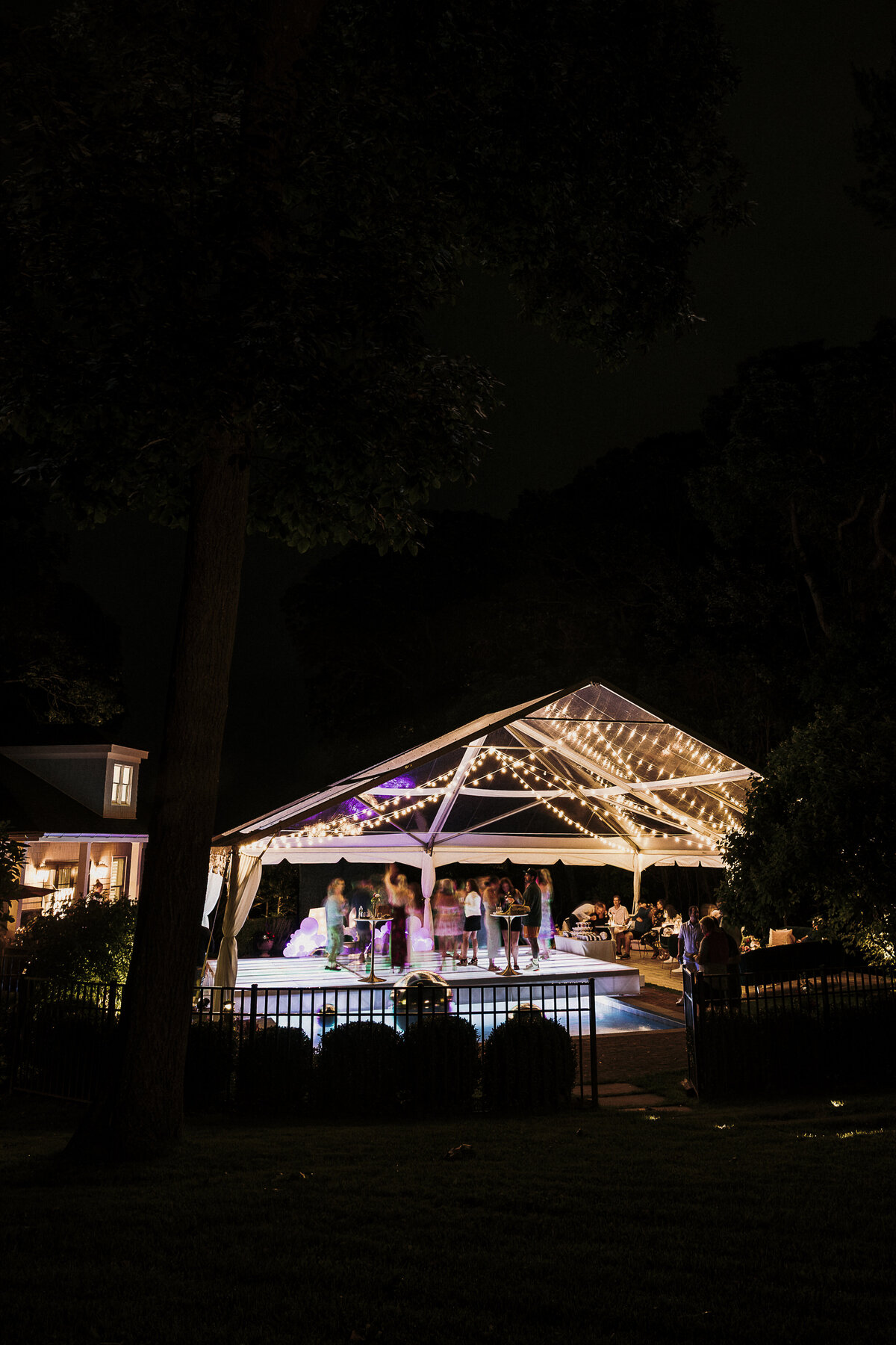 Photo of tent and string lights above the pool in private backyard party by Mira Park Photography NY based wedding photographer