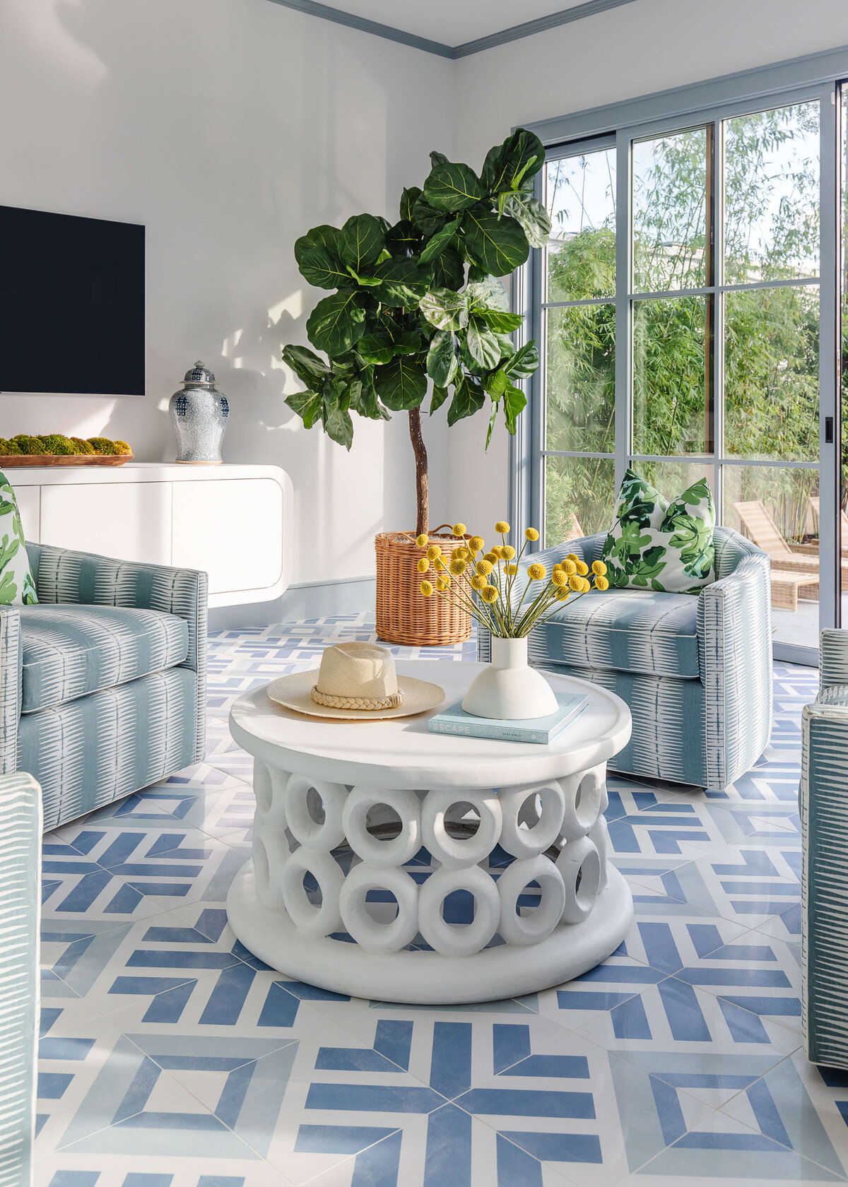 oyster creek studios memorial new build white ceramic coffee table with large plant and blue geometric rug in living room