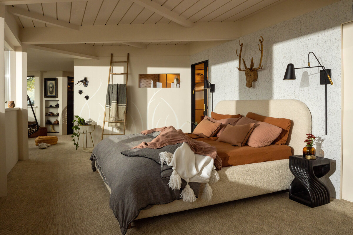 Interior photography of a cozy bedroom with earthy tones and natural light.