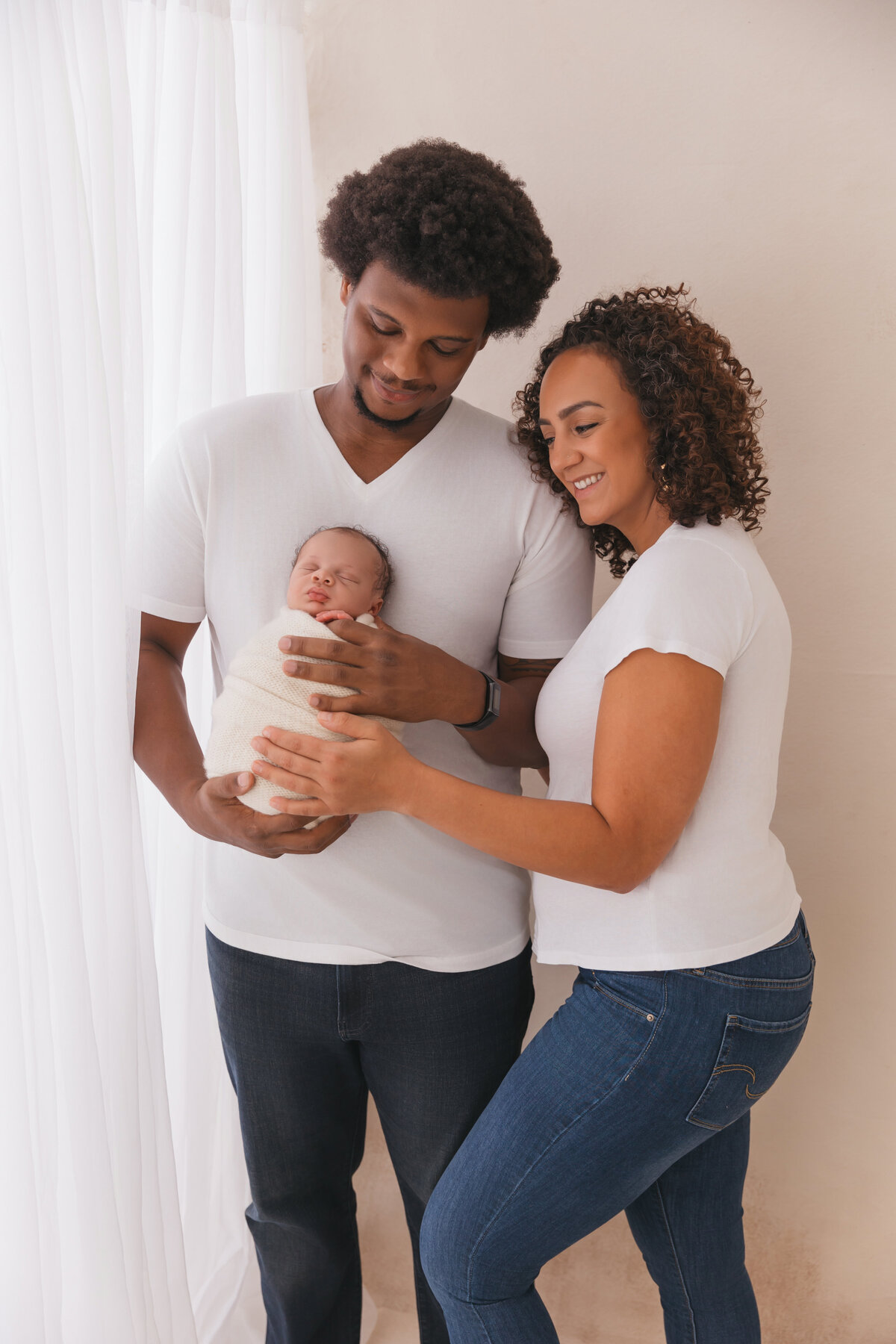 mom and dad holding baby during their phoenix newborn portriats