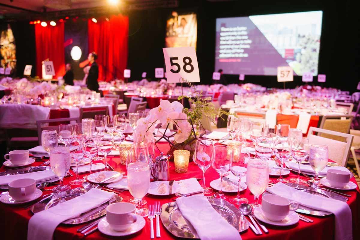 seattle university annual fundraiser with red linens and floral centerpiece