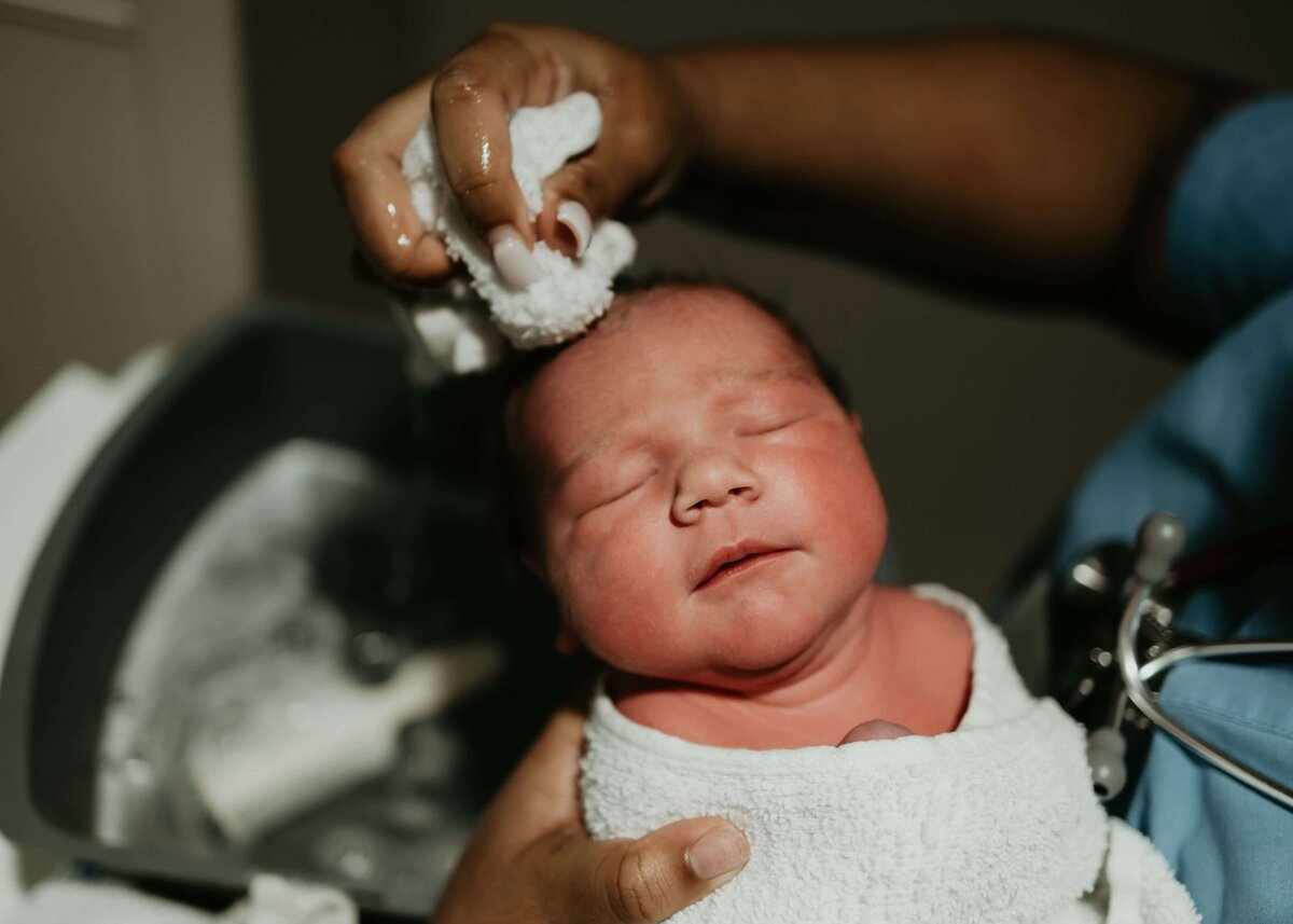 In Pittsburgh, a nurse gently washes a newborn's head with a towel.