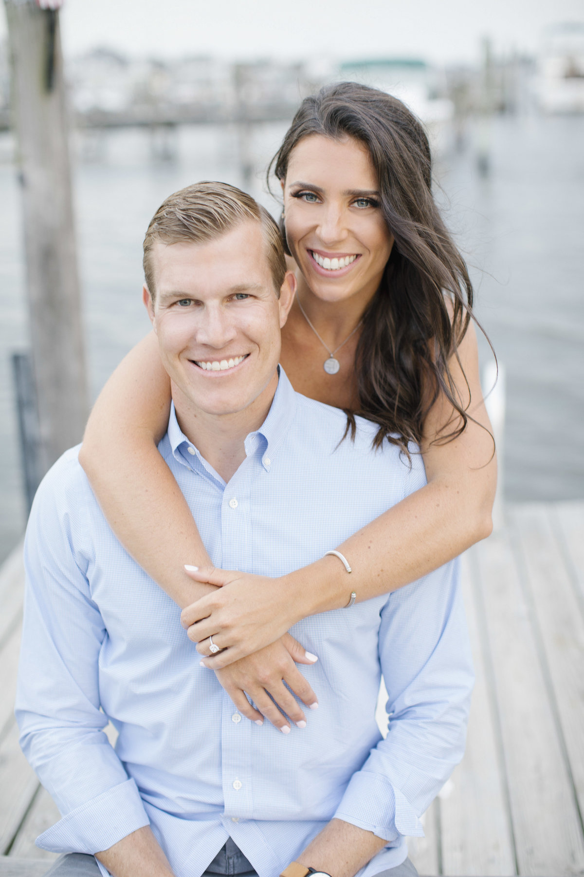 engaged couple hugging on dock in seas bright