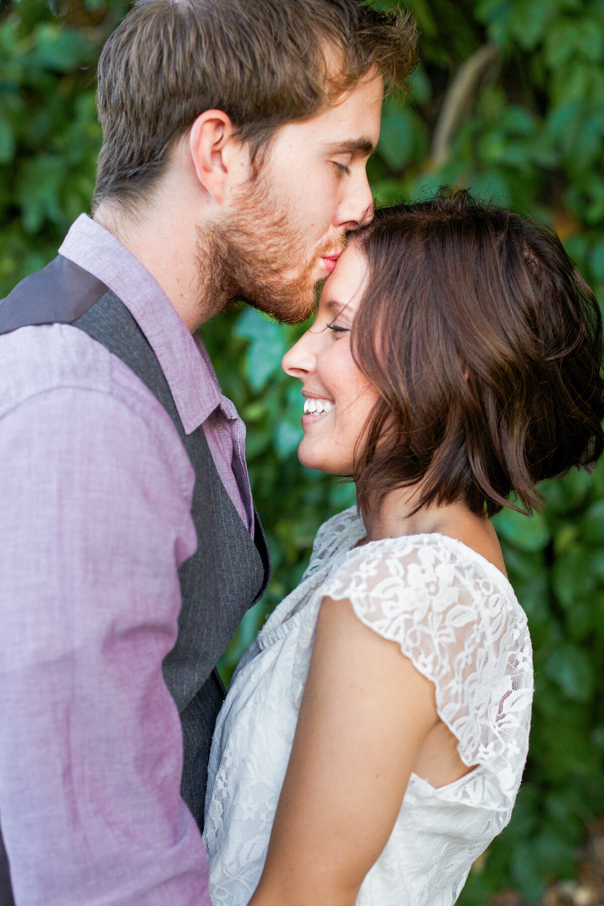 man kissing his fiance on the forehead