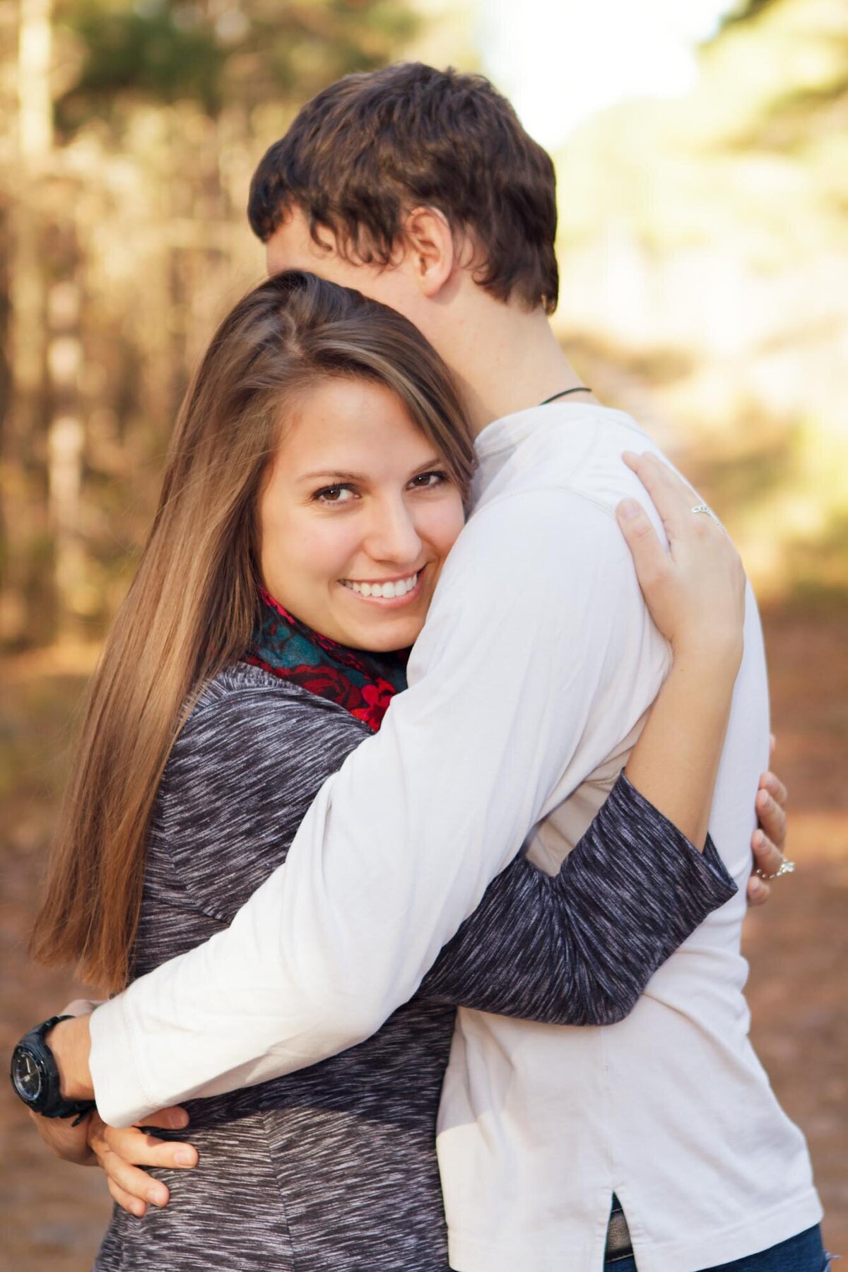 Engagement portrait of a couple holding onto each other and smiling in Peachtree City Georgia.