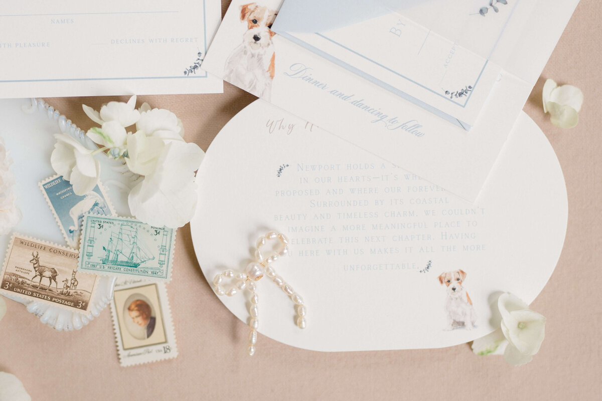 Custom coastal wedding invitation suite with delicate florals, classic typography, and a watercolor dog illustration by White Heart Design.