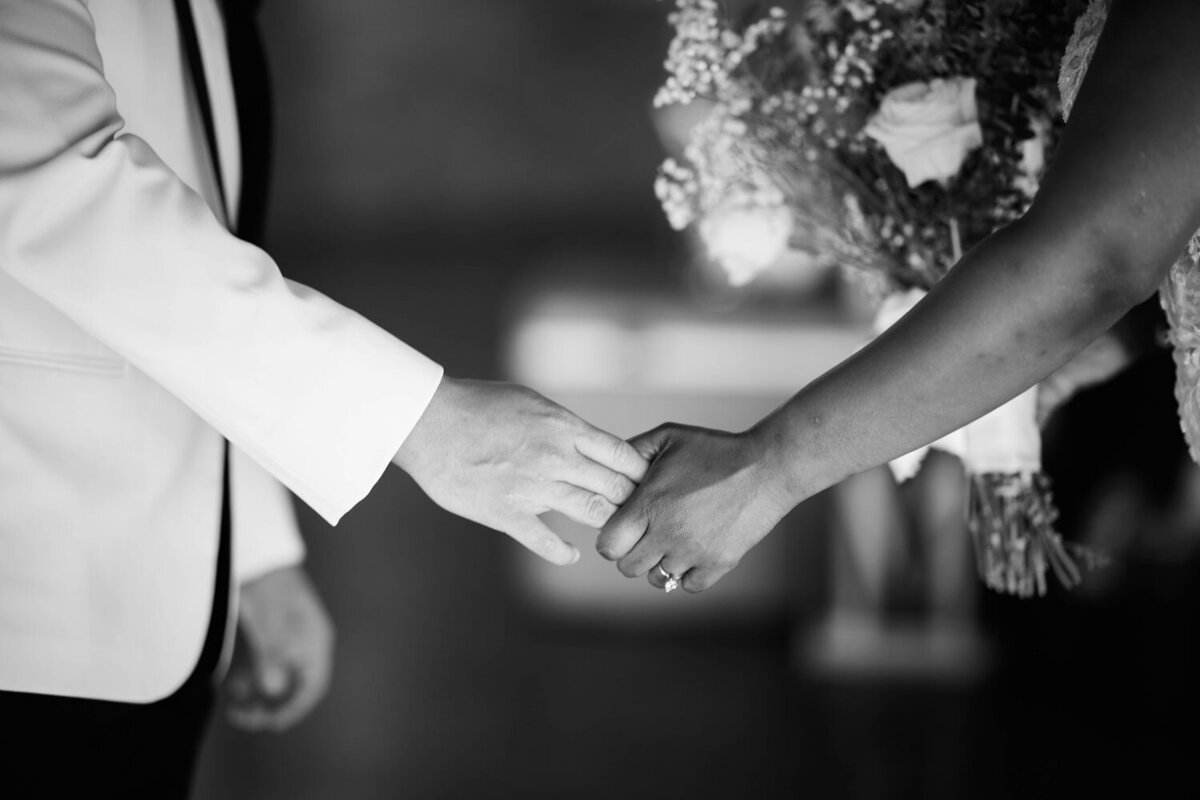 Bride and groom holding each other hands