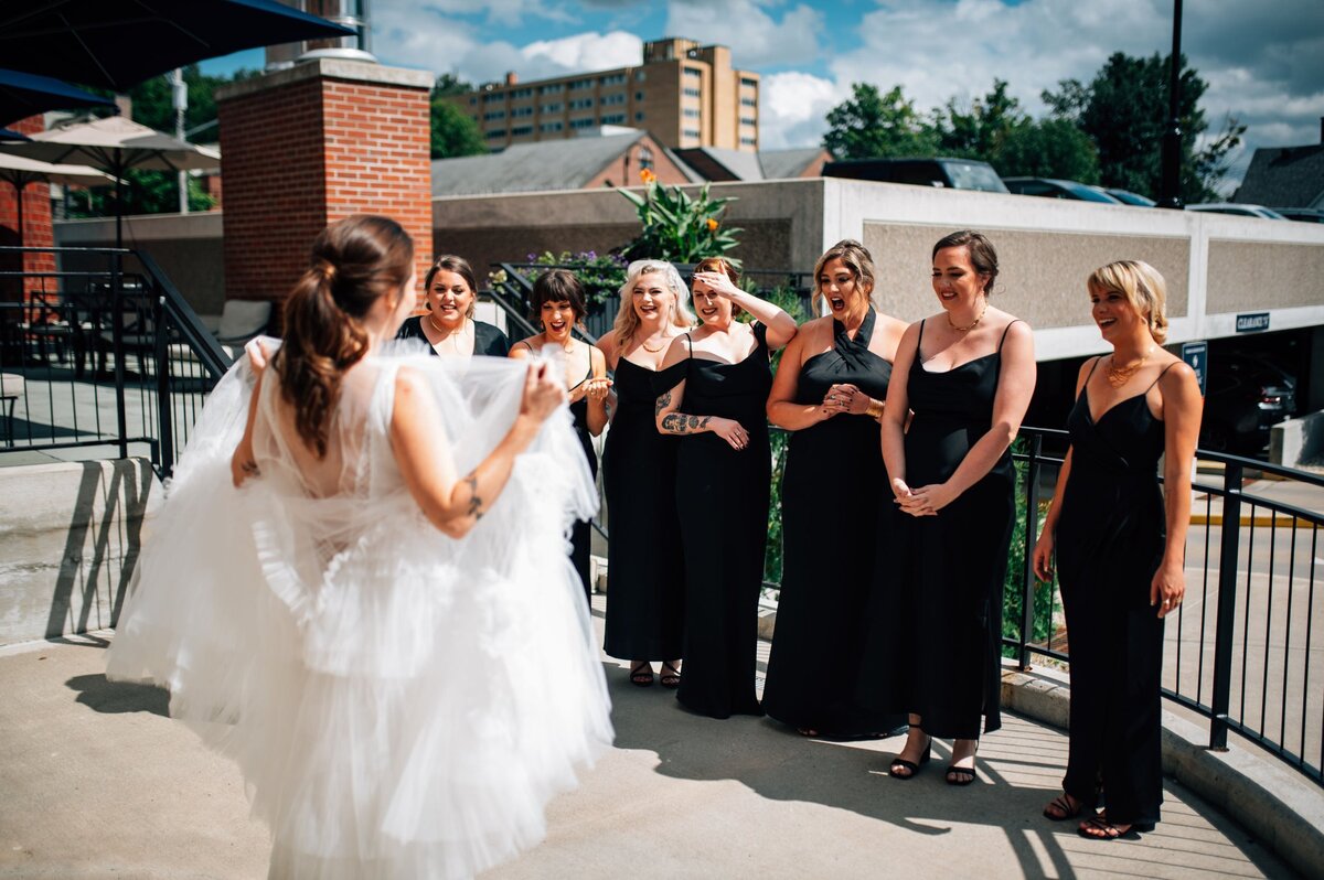 Bride showing her dress to bridesmaids