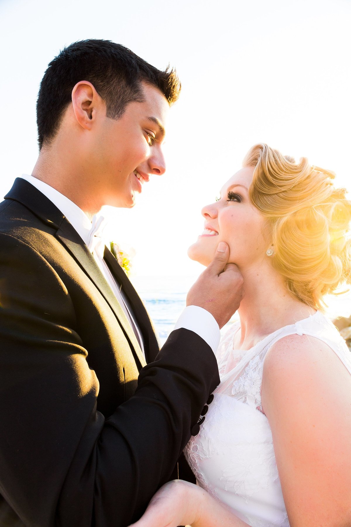 groom kisses bride in glowy sun