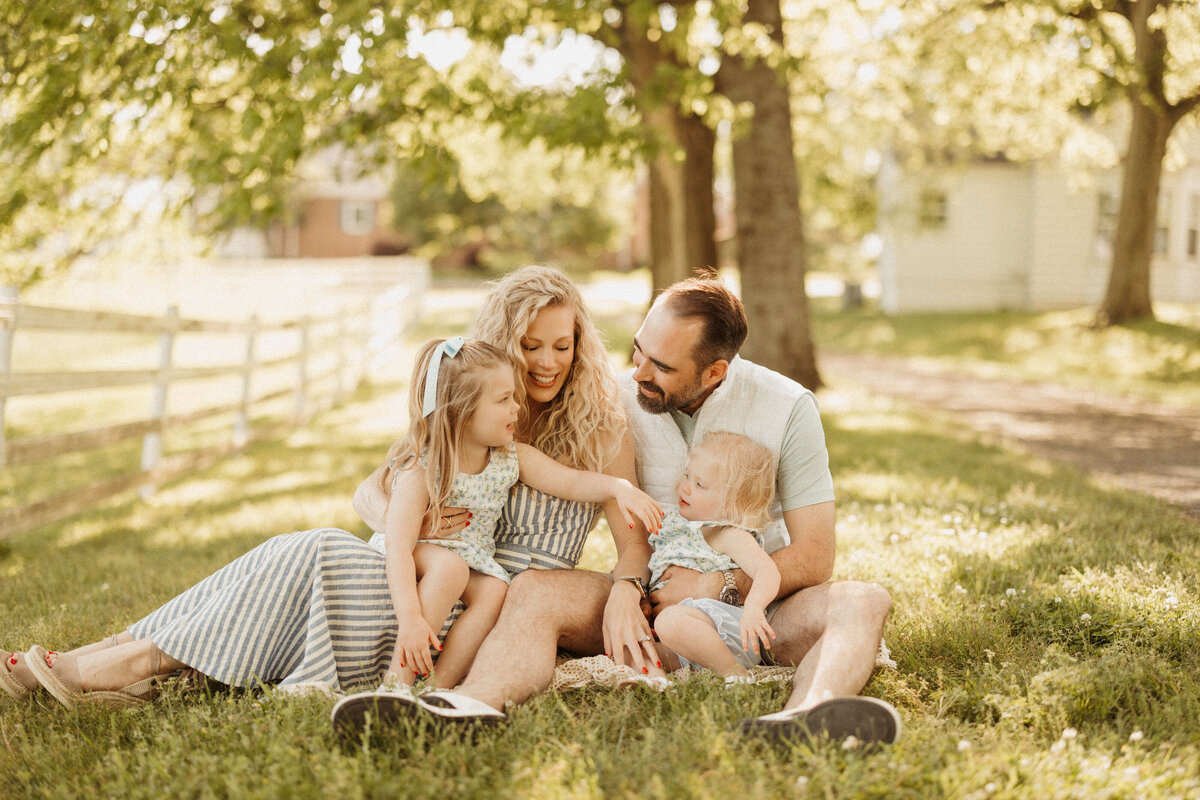 Family laughing together in a meadow during Nashville Tennessee outdoor photo shoot