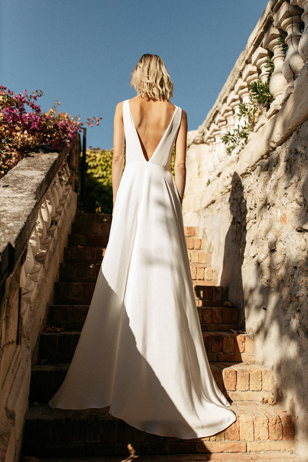 Deep v back wedding dress in silk, bride on steps of a villa in France