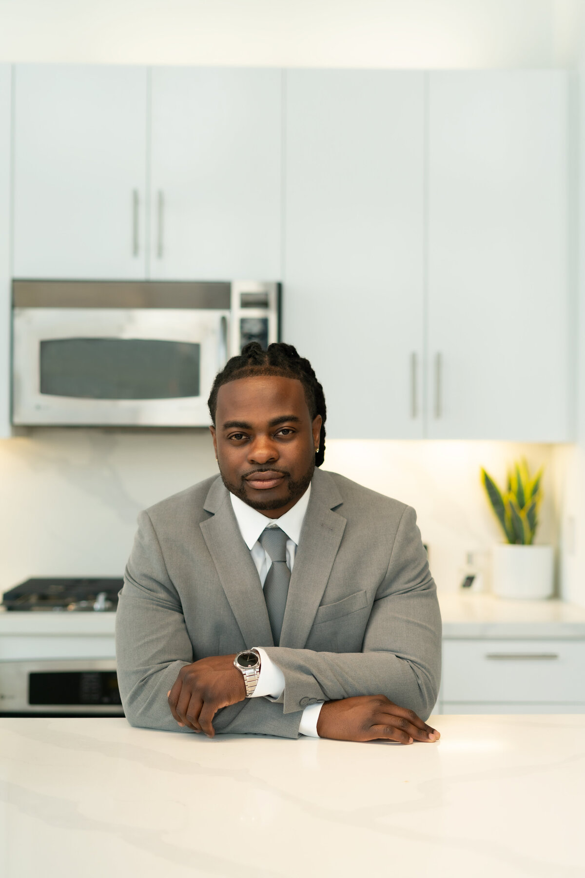 Black male real estate agent in gray suit in kitchen