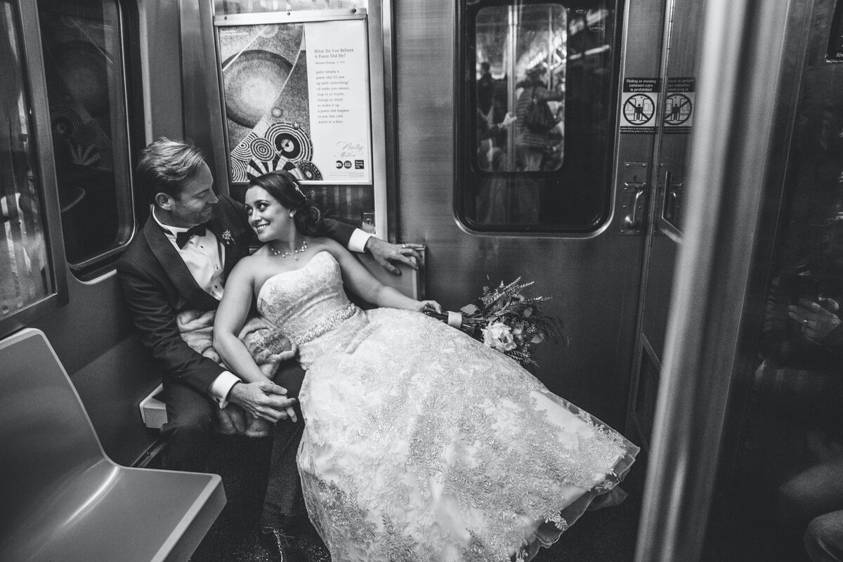 Black and white photo of a wedding couple on a subway.