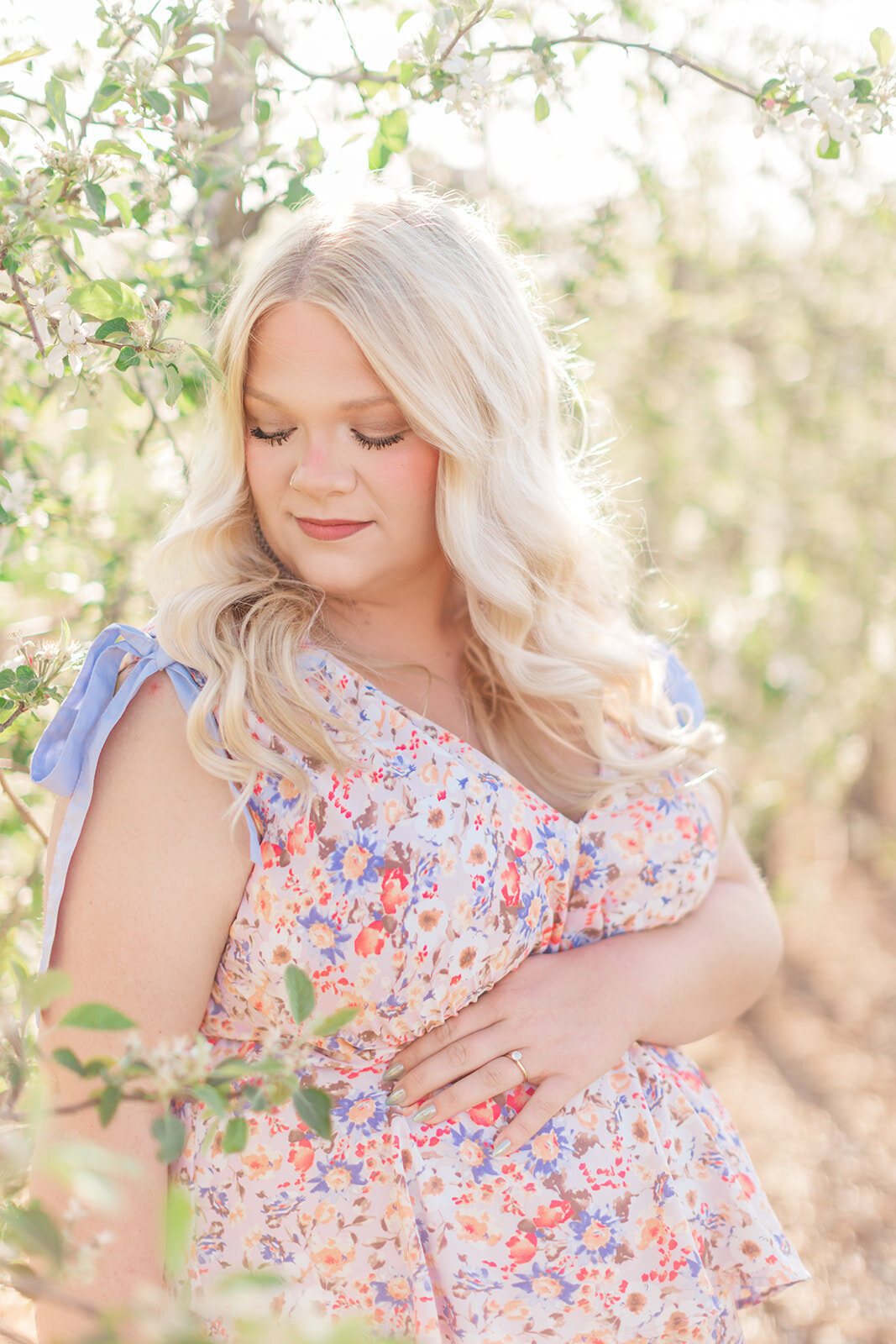 Candid maternity photo of couple laughing in orchard