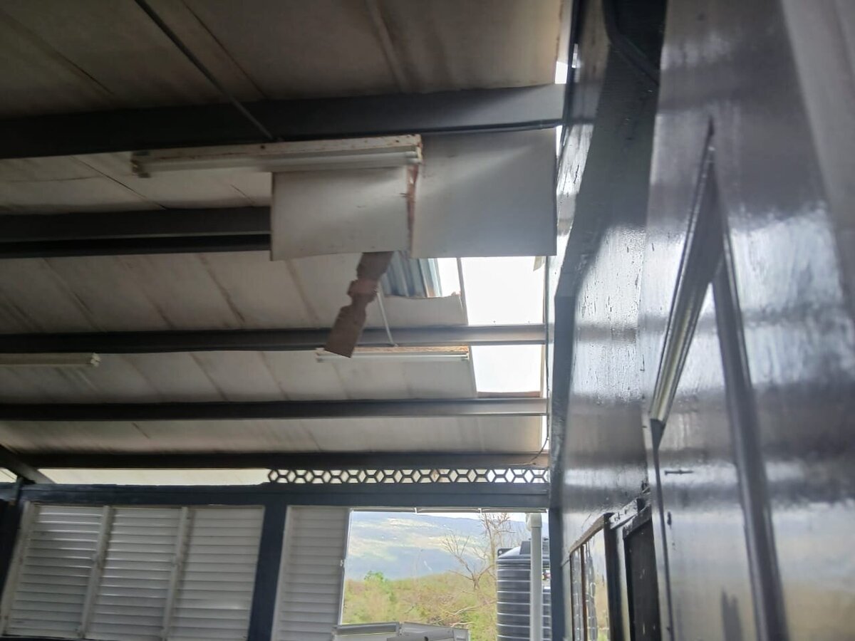 Ceiling panels fallen inside the classroom, showing significant structural failure from the storm.