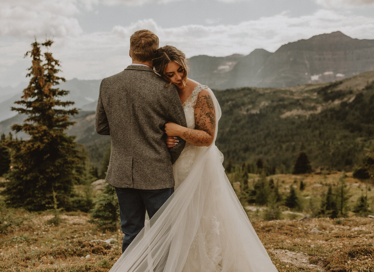 Bride leaning head on grooms shoulder  taking in Banff, AB