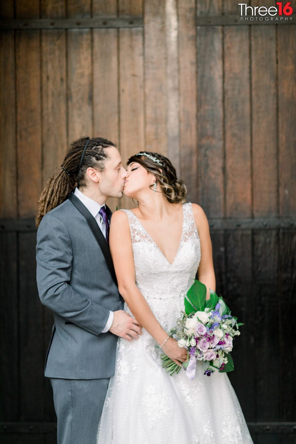 Tender kiss between Bride and Groom during photo session