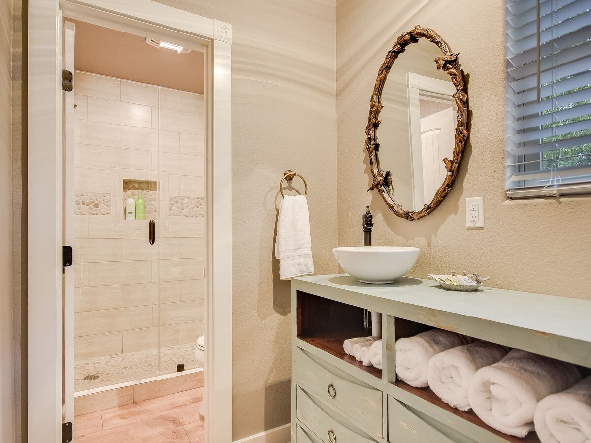 Smaller bathroom with golden mirror and white basin