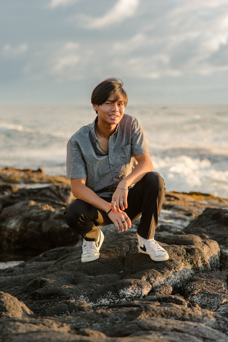 senior guy on the lava rock at the beach in hawaii