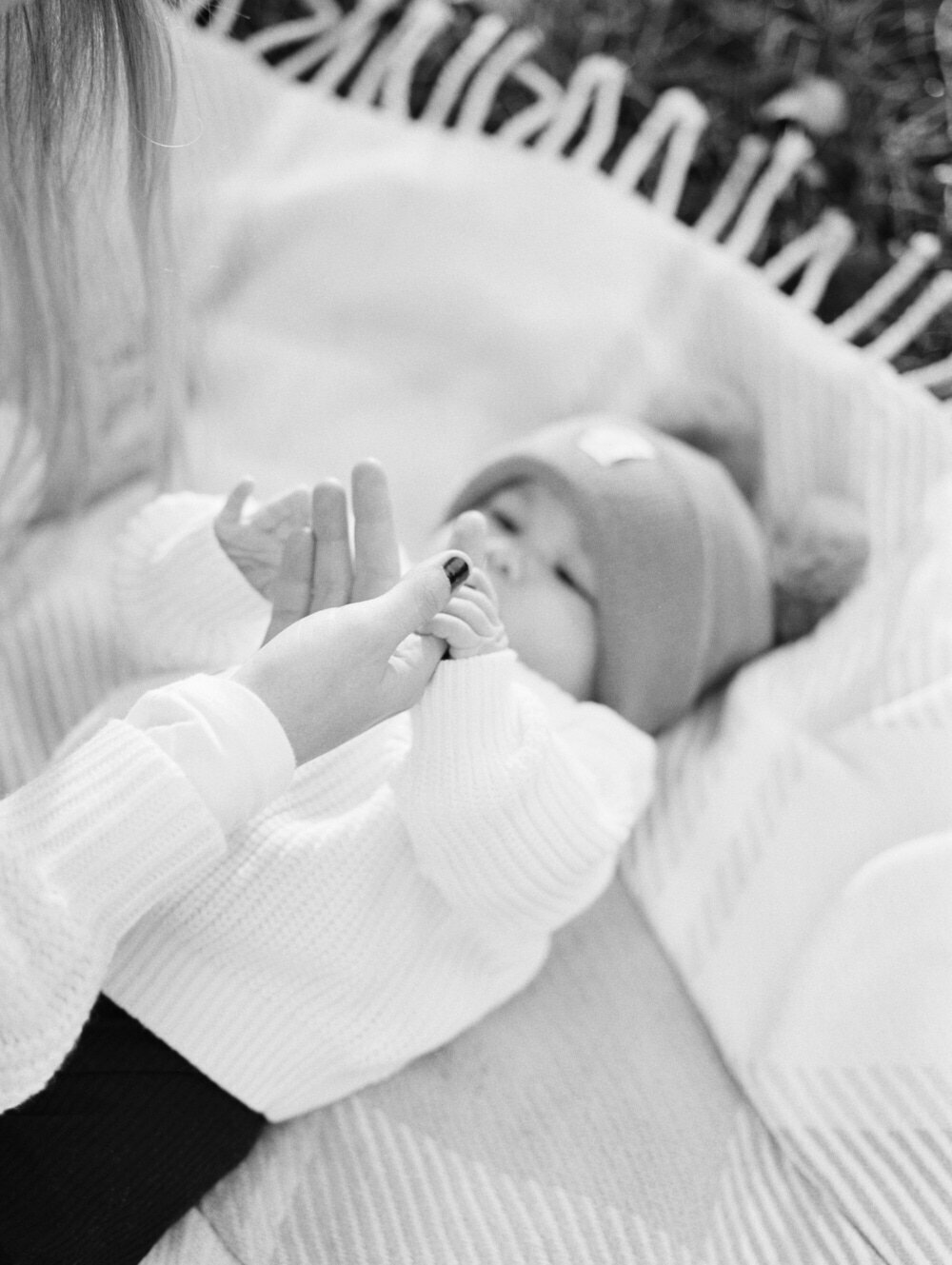 close up of mother holding little baby girls hand captured during family photo session