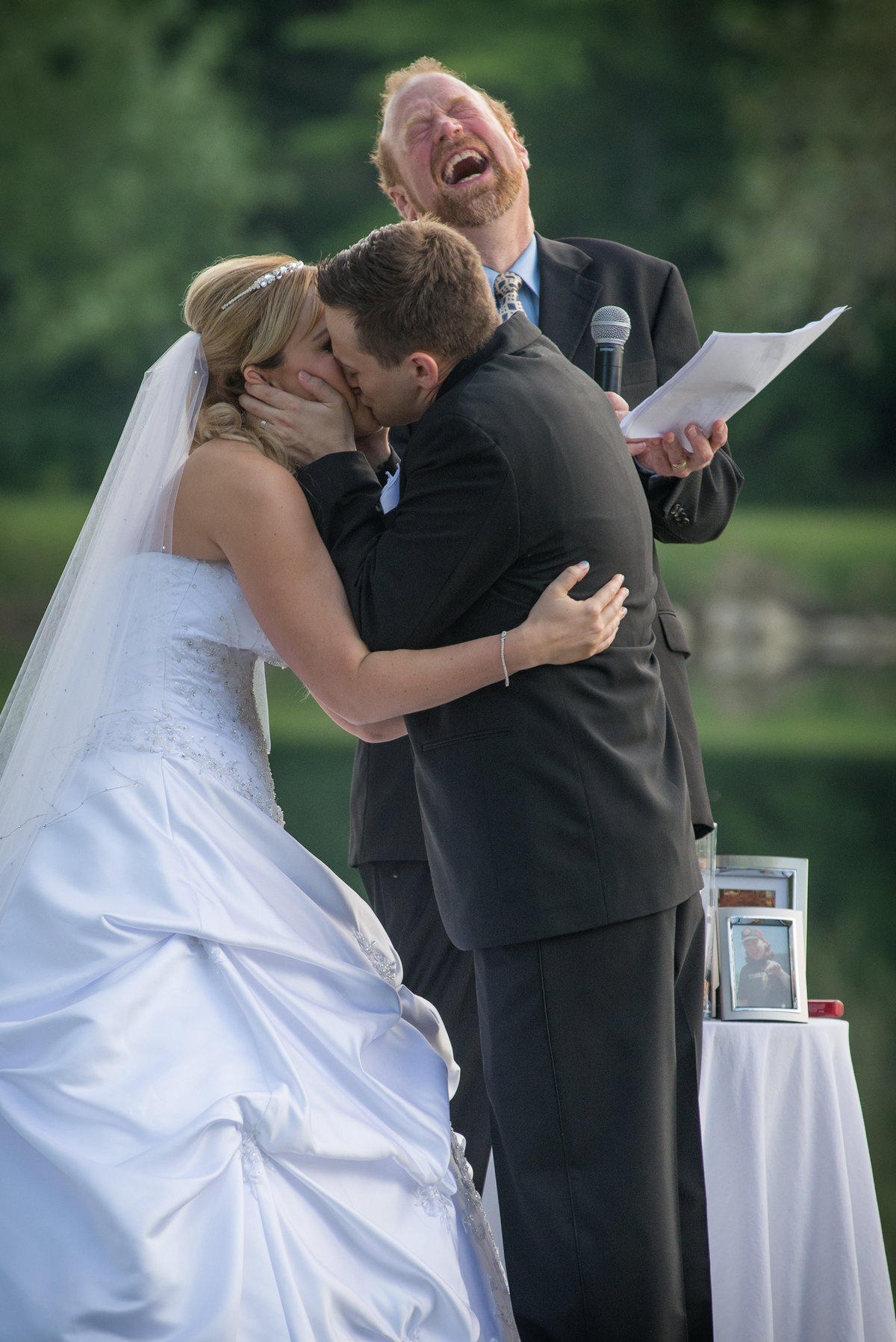 Pastor joyfully laughing during couples first kiss