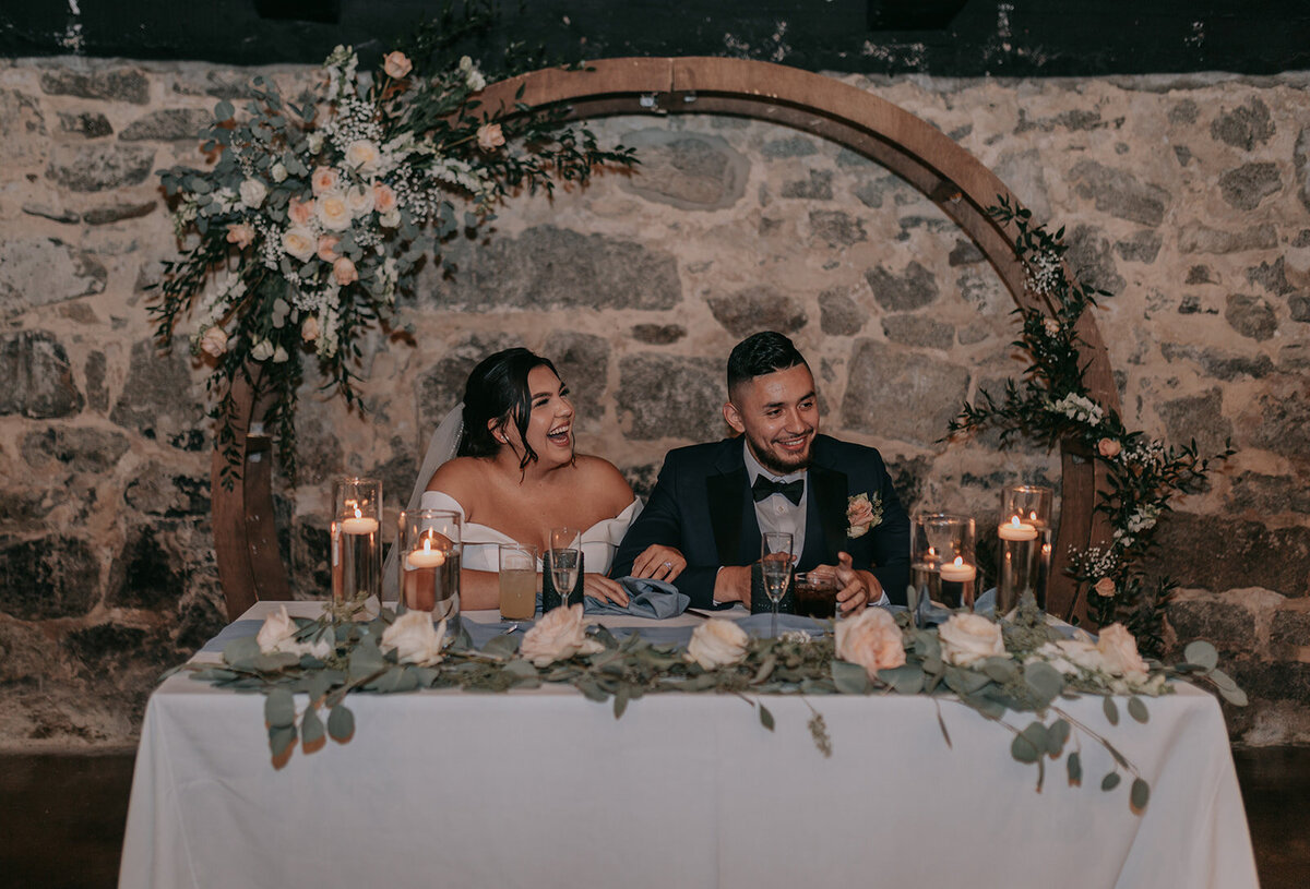 Bride and groom portrait with floral arch designed with colorful flowers