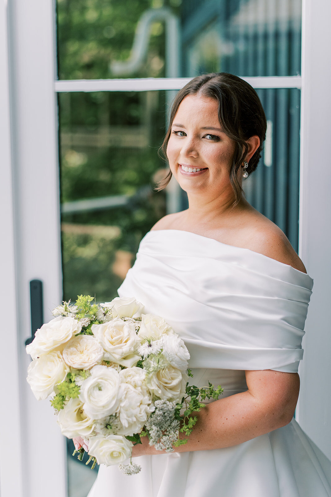 Classic white and green bridal bouquet with roses and lush greenery.