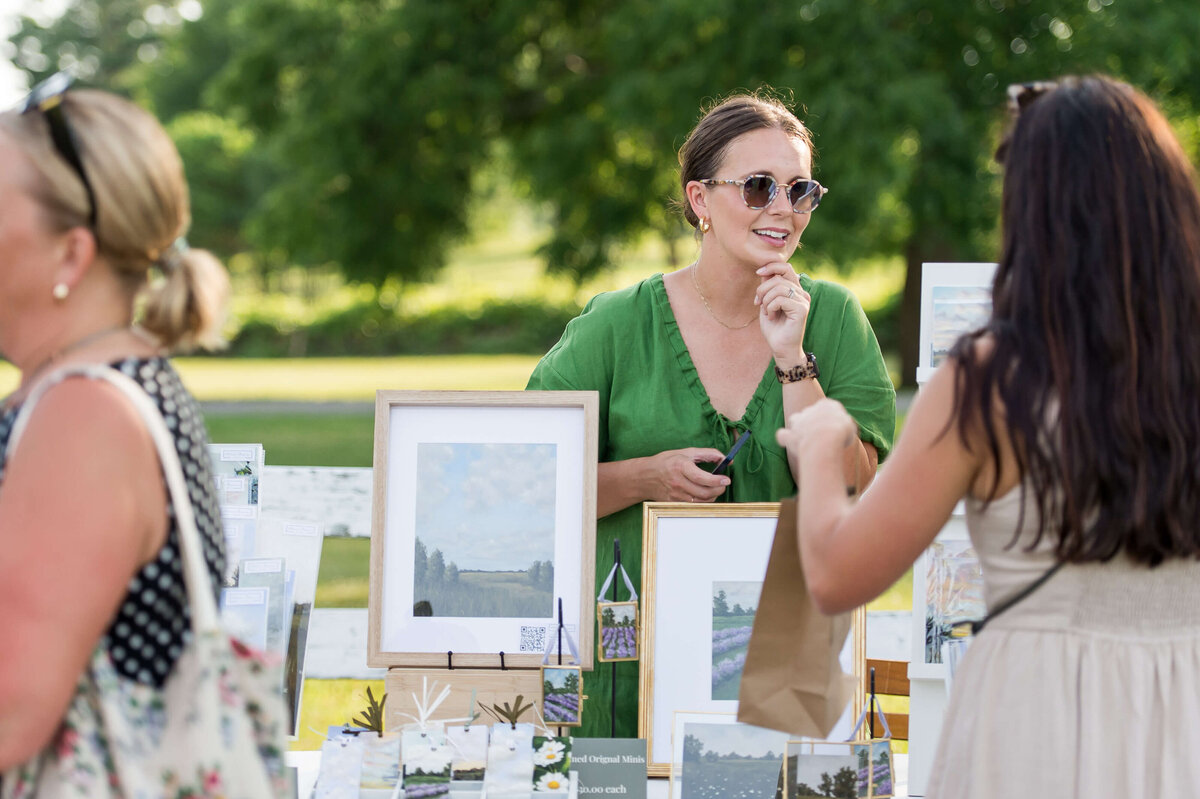 Ottawa event photos showing a market vendor interacting with a guest at Soiree in the Field.  Captured by JEMMAN Photography COMMERCIAL