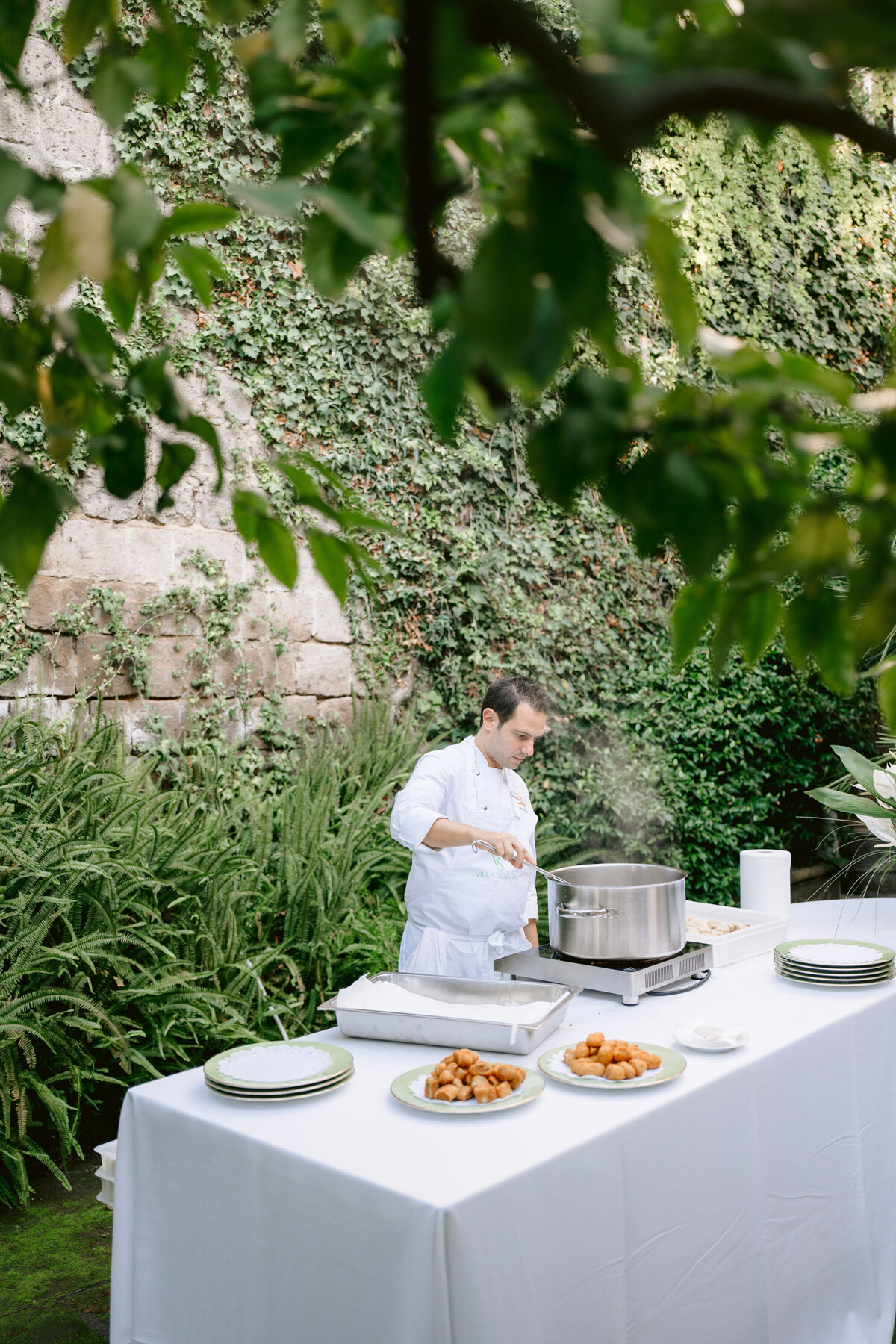 a chef in the gardens preparing arancini during the aperitivo cocktail hour