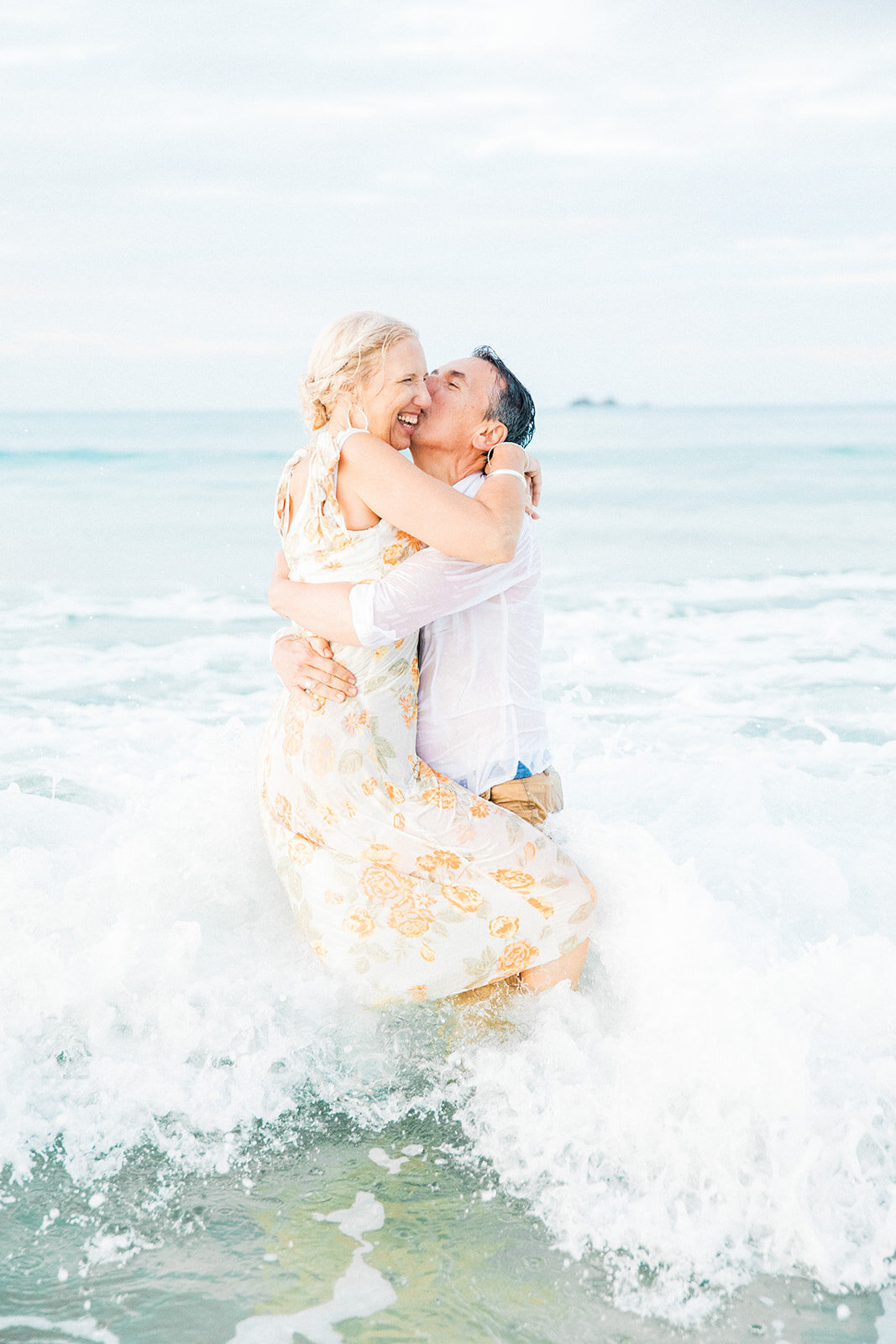 husband and wife playing in the ocean